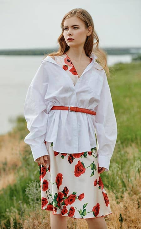 Chica Camisa Blanca Clara Y Un Vestido Floral Se Encuentra Pensativamente En La Orilla Del Rio | How To Style An Oversized Shirt: Types, Tips &Amp; Outfit Ideas Chica camisa blanca clara y un vestido floral se encuentra pensativamente en la orilla del rio
