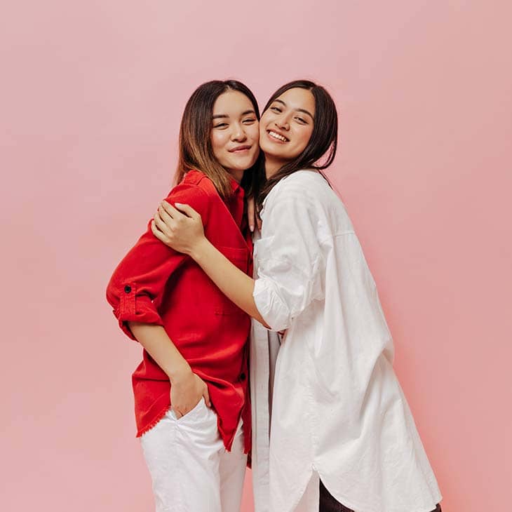 Two Women Hug Smile Red White Clothes | How To Style An Oversized Shirt: Types, Tips &Amp; Outfit Ideas Two women hug smile red white clothes